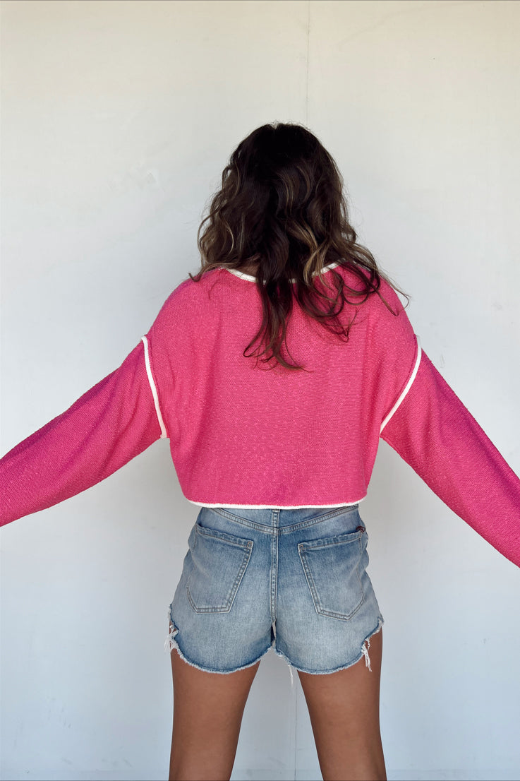 pink sweater with white trim detail 